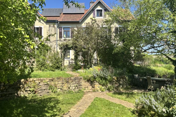 Sur les hauteurs de Cruchten, ample bâtisse du début XIXème et son jardin arboré de 11ares.